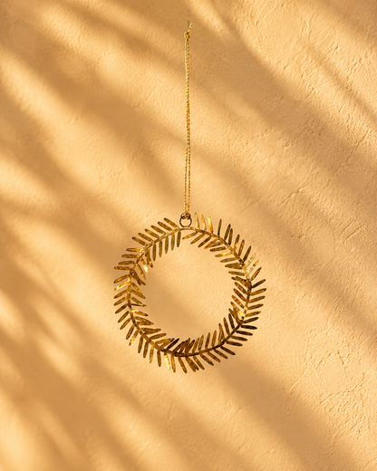 Lamet juleornament i messing formet som en rund krans med små dekorative blade, Ø 9 cm